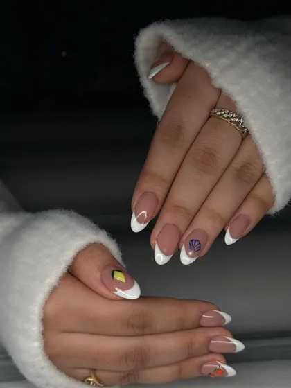 This set features a classic French manicure on almond nails with different tiny, hand-painted fruit and shell accents on each hand.
