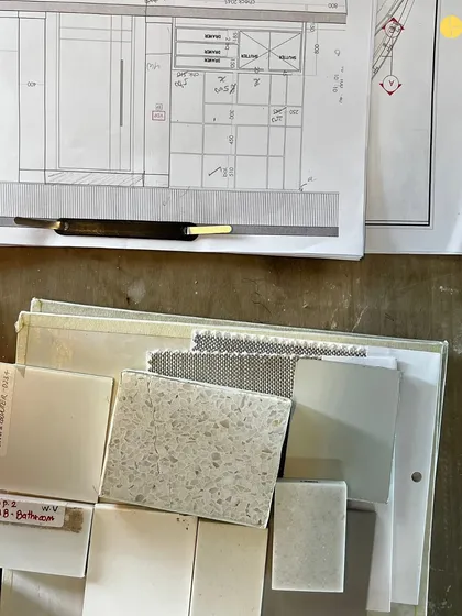 A glimpse of the organized chaos on site. Material samples for a bathroom in the 58WV project are laid out next to the architectural drawings, showing the bridge between plan and physical material.