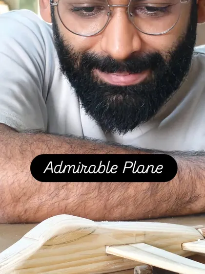 A student admiring the wooden airplane he just finished. There's a special kind of pride that comes from creating a toy with your own hands.