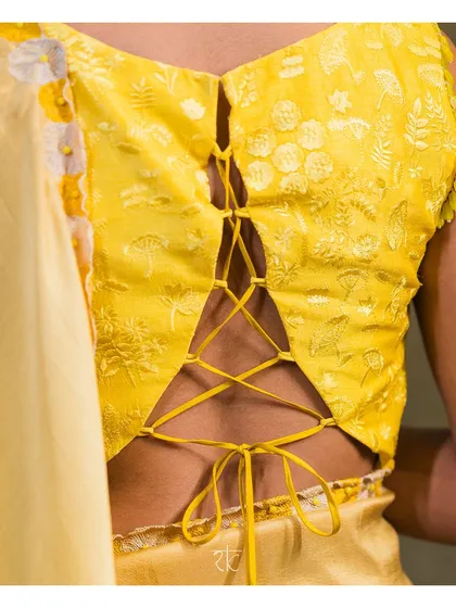 The back of this lime yellow blouse is designed with a modern corset-style tie-up, adding a contemporary twist to the traditional self-thread embroidery. It is a design that is beautiful from every angle.