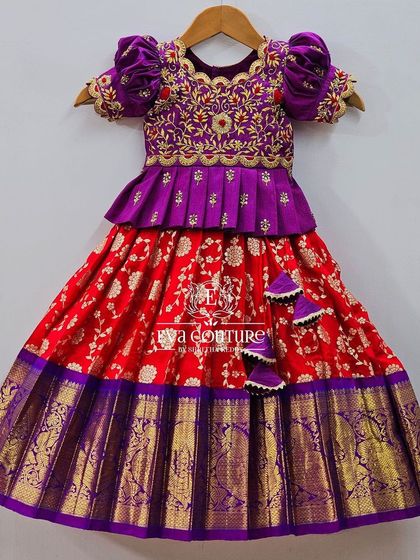 A grand Banarasi lehenga in red and purple. The blouse is heavily embroidered with velvet puff sleeves.