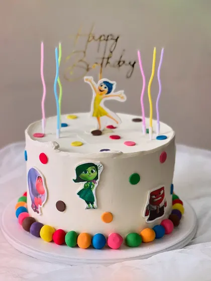 An "Inside Out" themed birthday cake made with my Belgian Chocolate flavor. It's decorated with colorful polka dots, character cutouts, and rainbow candles.