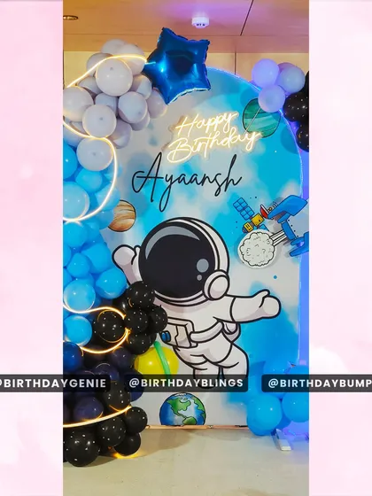 A focused shot of the central astronaut and personalized neon sign from the space party.