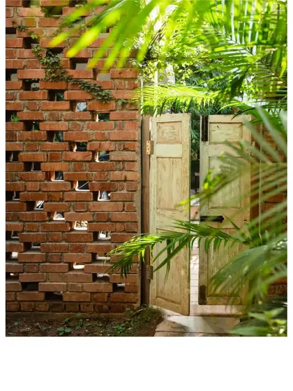 Another angle of the vintage door and jaali brick wall. The design allows for ventilation and a playful peek-a-boo effect, while the upcycled door adds a touch of rustic elegance.