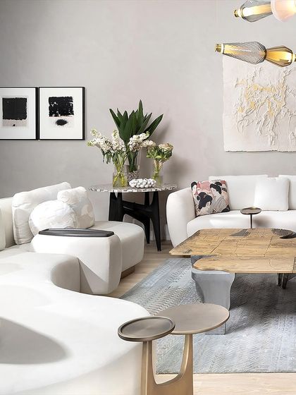 This living room setting showcases several pieces from our Koko collection. The armless 'Curved Couch', the cast brass 'Twin Table', and the unique 'Plateau Coffee Table' come together to create a space that is both elegant and artistically expressive.