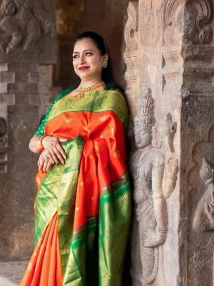 I am pictured here at a temple, draped in a vibrant orange and green Kanchipuram silk. For me, every saree is a tribute to the divine feminine.