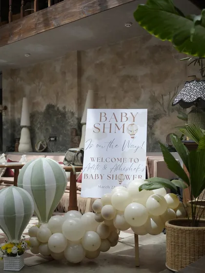 The welcome setup for the 'Baby Shmo' shower, with a personalized sign, balloon clouds, and miniature hot air balloons to set the theme.