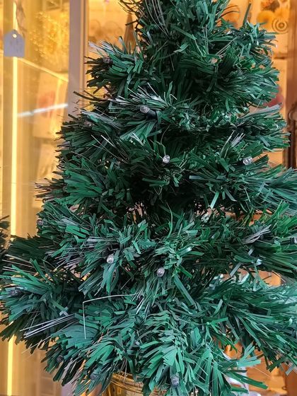 A small, simple tabletop Christmas tree with built-in fiber optic lights. It's a great, low-maintenance option for adding a bit of festive cheer to your office desk or a small room.