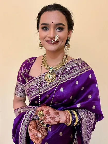 A happy bride showing off her complete look. The traditional jewelry and nath are perfectly complemented by the soft, glowing makeup.