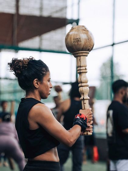 A woman stands with focused determination, holding a Gada during our L1 Certification program. This image showcases the dedication and strength of the women in our tribe, ready to learn and grow.