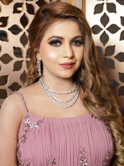 A close-up on the delicate silver embroidery and the client's beautiful makeup and jewelry.