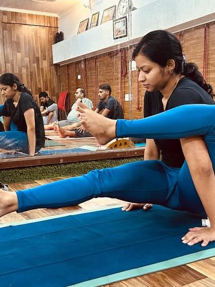 A student demonstrates a challenging arm balance, Eka Pada Koundinyasana, showcasing the progress made during the course.