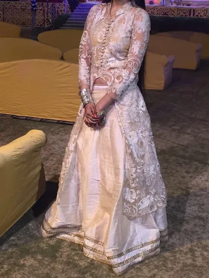 A client wearing our fusion ivory skirt and sheer jacket set at an evening function. The long, embroidered jacket adds an element of sophistication to the outfit.