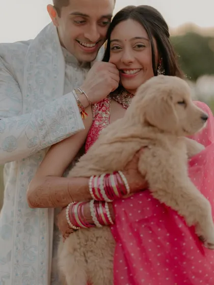 Another adorable shot of the couple with their furry friend. The groom's playful expression and the bride's happy smile make this a truly joyful and memorable photo.