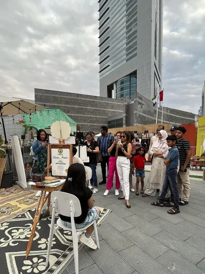The crowd gathers! A shot of my booth in Dubai, with a curious audience watching the live art unfold.