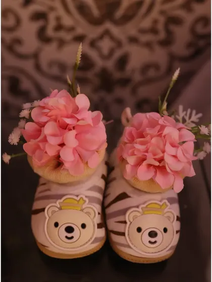 It's all in the details! Even the tiniest baby shoes, filled with delicate pink flowers, became part of the adorable decor.