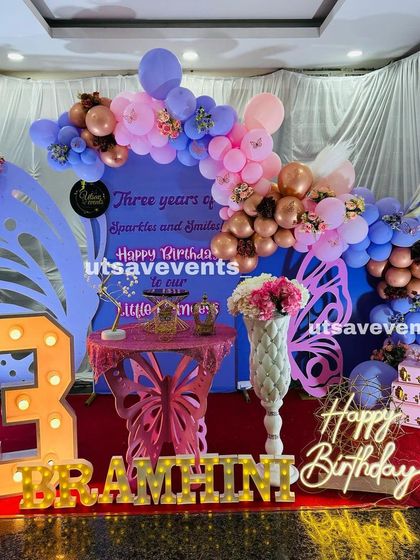 A unique butterfly-themed birthday decoration with a custom backdrop and marquee letters. The pastel balloon garland and butterfly table create a whimsical atmosphere for the celebration.