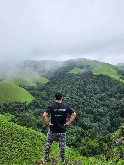 A moment of contemplation on the Bandaje falls trail, overlooking the lush green valleys of Chikmagalur.