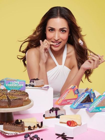 A sweet and chic hairstyle for Malaika Arora's Getaway Desserts campaign. The hair is styled to look effortlessly glamorous, even when enjoying a delicious cheesecake.