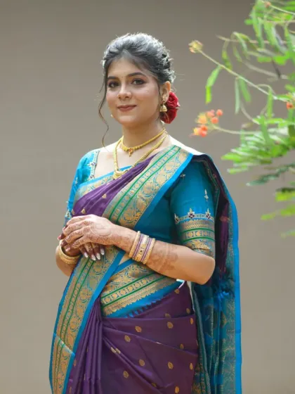 A classic pose showcasing the bride's complete look, from the neat hairstyle to the perfectly draped saree.