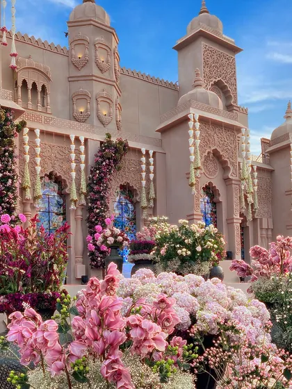 Here, I built a magnificent palace facade adorned with thousands of fresh flowers. The combination of intricate architecture and lush floral arrangements in shades of pink creates a stunning visual for a royal-themed wedding.