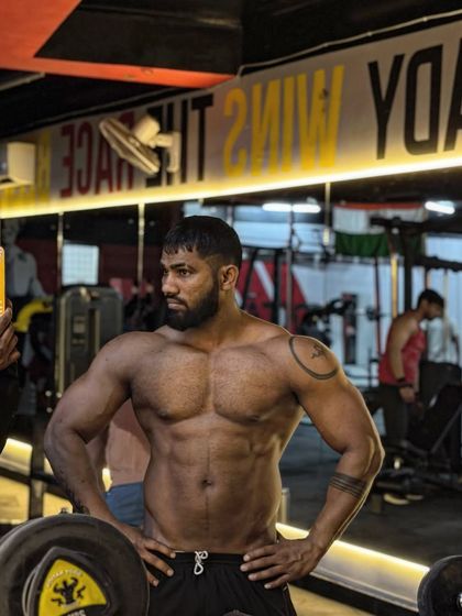 A powerful pose showing my chest and arm development. The lighting is key to highlighting the details.