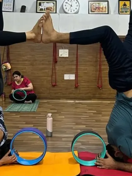 This partner headstand variation is a testament to balance, strength, and trust. Students work together to create a symmetrical shape, mirroring each other's stability.