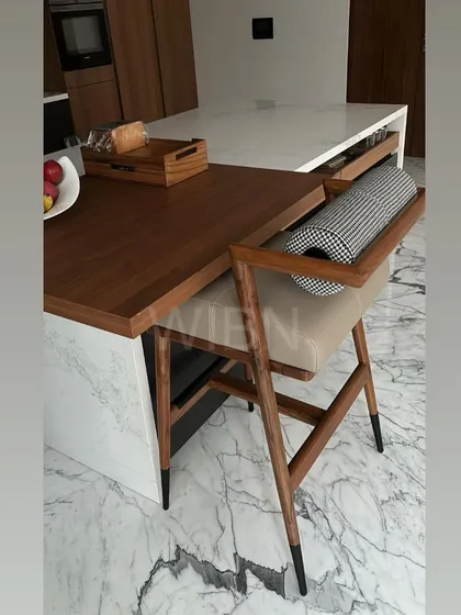 The barstool in context, showing how it perfectly complements the client's modern kitchen with its marble countertops and wood accents.