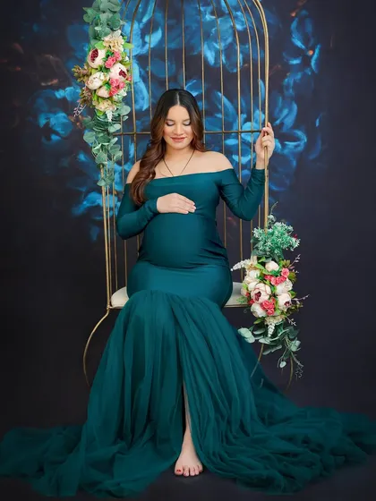 My studio is equipped with unique props like this floral birdcage swing to create elegant and whimsical maternity photos. This portrait in a stunning teal gown highlights the serene beauty of pregnancy.
