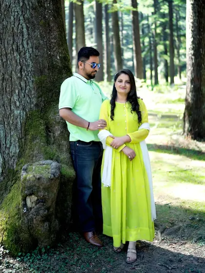 A pre-wedding portrait in a lush green forest, showing the couple in casual attire. This highlights the versatility of mountain shoots, from formal to relaxed.