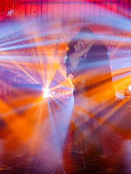 When the lights go down, the party starts. I love playing with dramatic lighting to capture the energy of a couple lost in their own world on the dance floor.