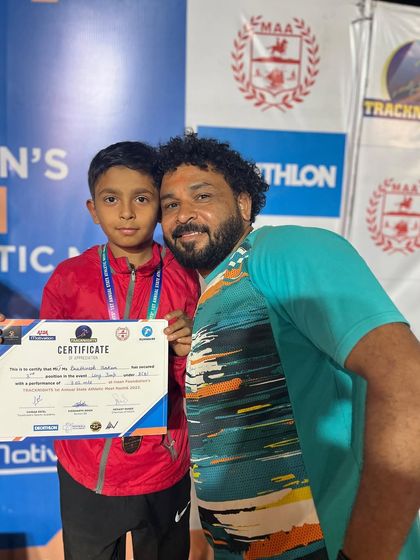 A young athlete and his supporter celebrate his achievement at the awards ceremony.