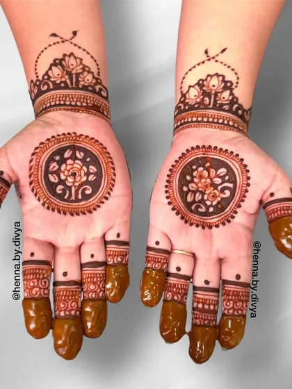 A classic and elegant mandala design on the palm. The central floral mandala is surrounded by a thick border, with a matching lotus cuff and detailed finger work.