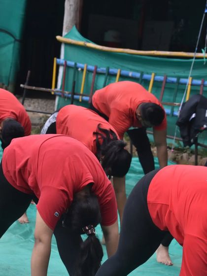 A yoga retreat group practicing a forward bend together. Retreats offer an immersive experience to deepen one's practice.
