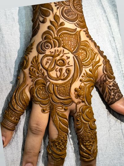 Another example of custom calligraphy, with a name elegantly placed in the center of the palm and surrounded by my signature detailed patterns.