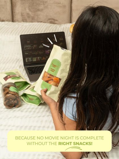 No movie night is complete without the right snacks! A girl enjoys a bag of my wholesome treats while binge-watching, making it a perfect, guilt-free evening.