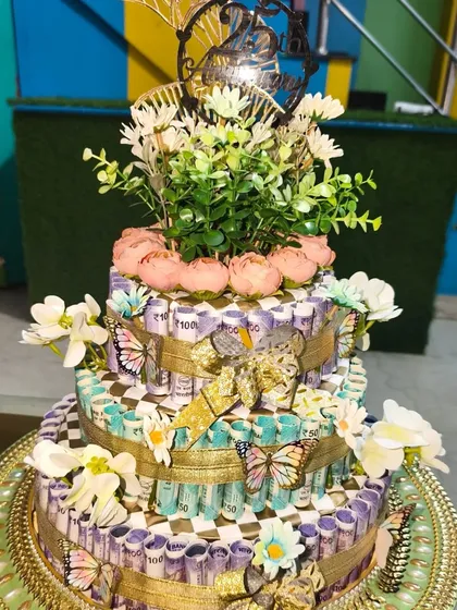 Another angle of the 25th anniversary cash cake, showing the floral topper and butterfly details. I can customize the theme and amount for you.