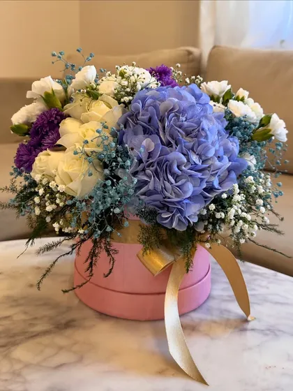 Another view of this beautiful assorted flower box. The combination of blue hydrangeas, white roses, and purple statice creates a lovely cool-toned palette.