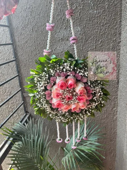 A hanging floral purse, or 'potli', made with a ball of pink roses and baby's breath. This is a beautiful accessory for the mom-to-be.