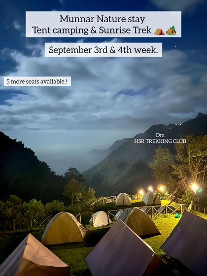 The Munnar campsite illuminated at dusk, with tents ready for guests and a sea of clouds settling in the valley below.