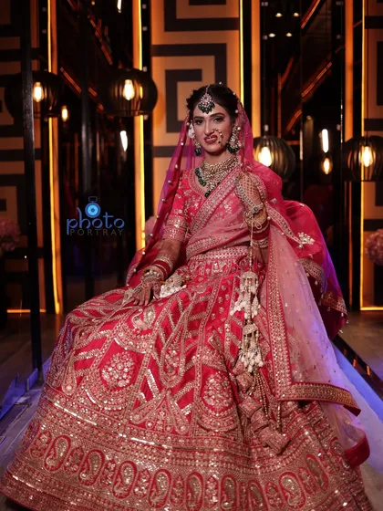 A regal bridal portrait with the bride seated, allowing her magnificent lehenga to be displayed in its full glory.