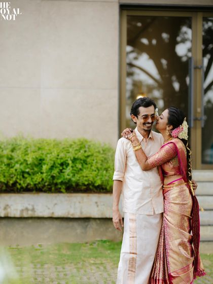 A candid moment from Rajesh Madhavan and Deepthi Karat's wedding. The groom's simple, perfectly pleated mundu allows for comfort and movement while maintaining a classic South Indian wedding style.
