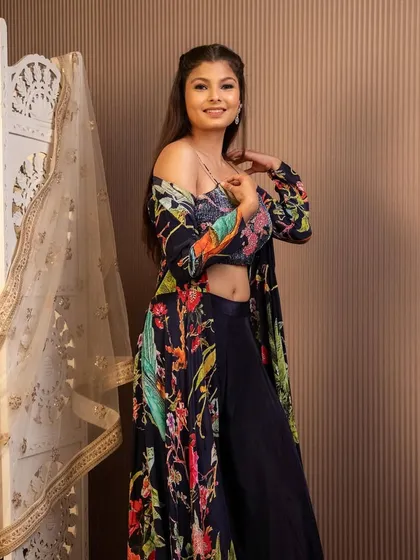 This dark floral printed co-ord set with a matching longline jacket is a chic and modern choice for a cocktail party or sangeet. It's effortlessly stylish.