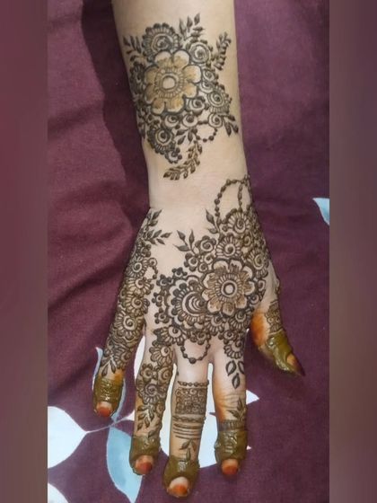 A lovely floral design for a party or festival. The pattern features a large floral motif on the palm with a matching design on the wrist, creating a cohesive look.