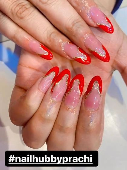A bold and festive look with bright red V-shaped French tips outlined in gold glitter. This design is perfect for making a statement during Karwa Chauth or any celebration.