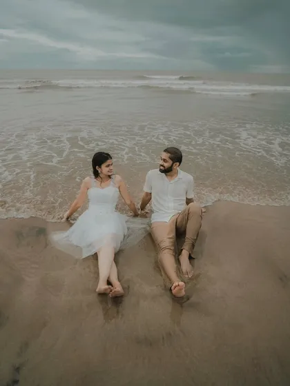 Sitting together as the waves wash over their feet. This peaceful pre-wedding photo of Pragati and Swapnil captures a moment of shared serenity on the beach.