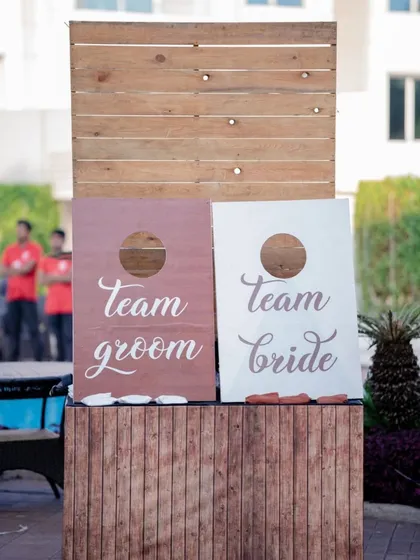 A classic cornhole game customized for "Team Bride" and "Team Groom," sparking some friendly competition.