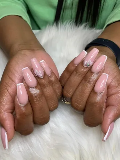 A beautiful and elegant set featuring a soft pink base, classic white French tips, and a delicate 3D flower accent.