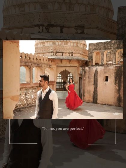 A dynamic composition at Amer Fort, with the groom in the foreground and the bride in a flowing red dress in the background, creating a sense of story and movement.