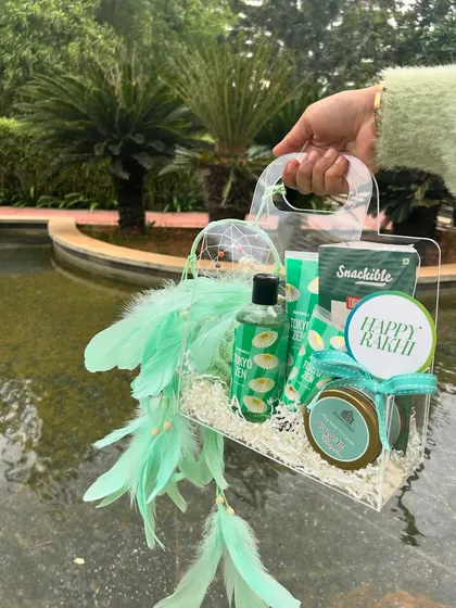 A fresh, green-themed hamper with a feather dreamcatcher. Adding unique, handmade elements can increase the perceived value of your gifts.